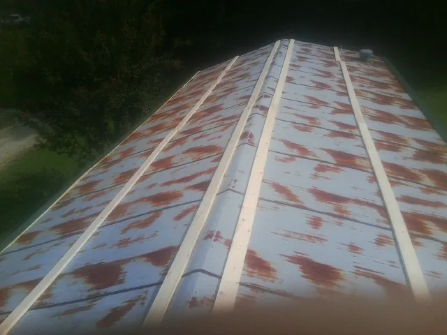 Rusted metal roof panels with new wood purlins before replacement — Storm Damage Roof Repair in Harbor City by Roofing Brothers
