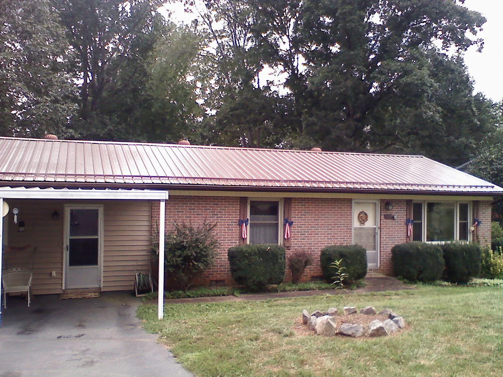 Bronze metal roof and carport on a brick ranch home — Roof Repair work by our crew in Harbor City