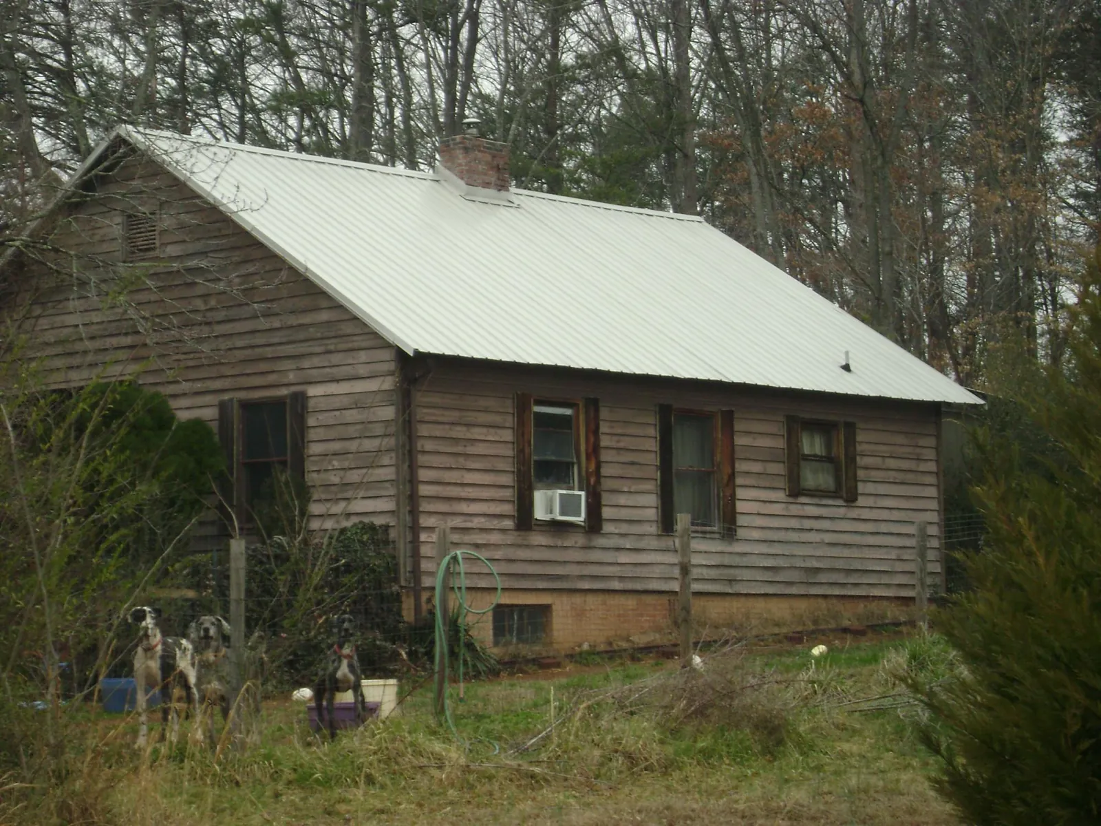 White metal roof on an old wood sided farmhouse, from a Metal Roof Installation job in Harbor City